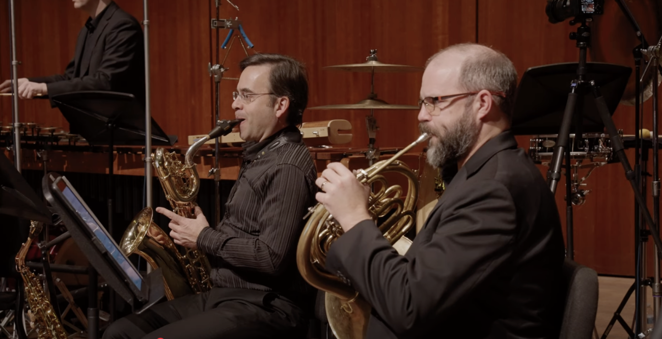 Taimur Sullivan playing saxophone and Matthew Oliphant playing French horn